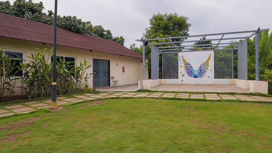A facade image of a lawn with a logo of the resort - Trance Veechika Resort, Vikarabad