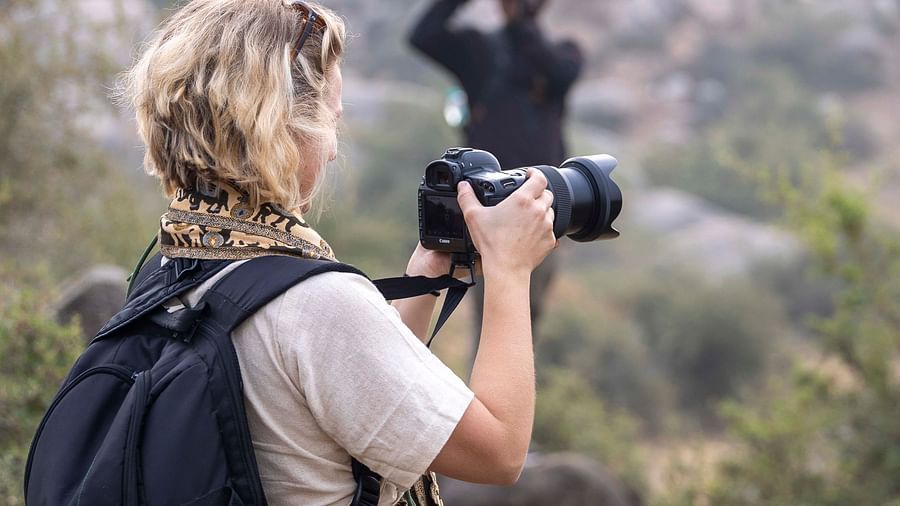 An image of a woman clicking pictures of the views with a camera - Utsav Camp Sariska