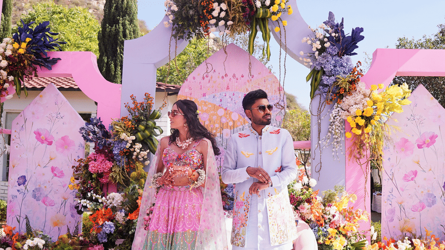 2 guests beside a decorative photo backdrop at Valley by Grassfield, a wedding resort in Jaipur.