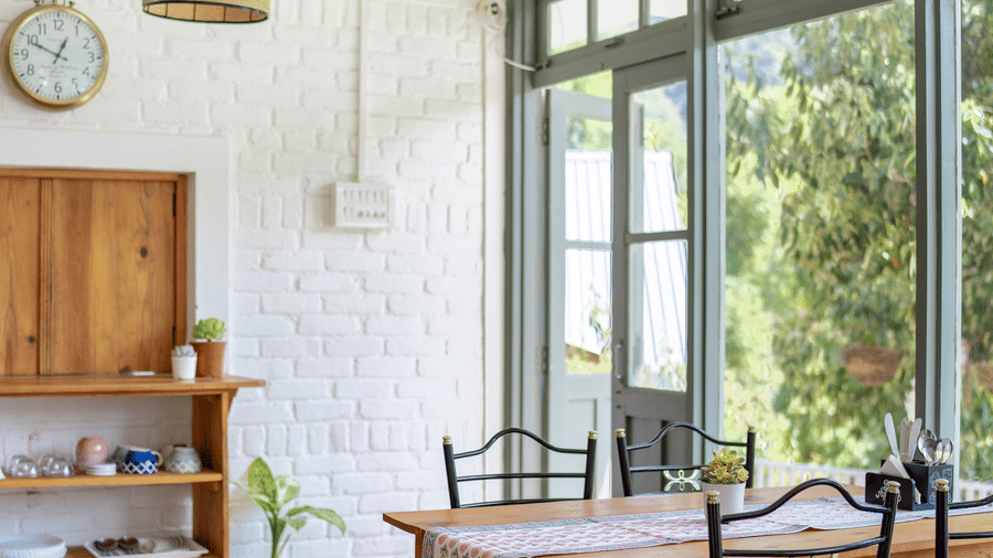 A dining table with chairs next to a window at Ziran Retreat.