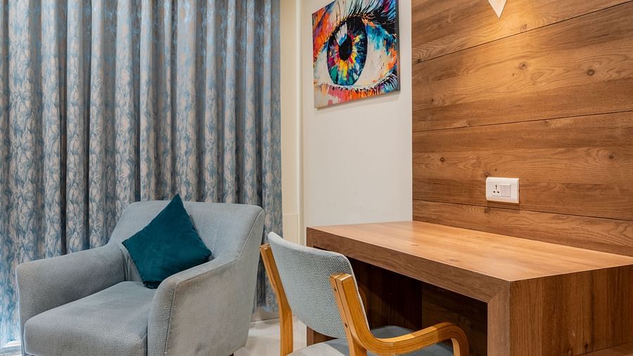 Compact corner view of room featuring a writing desk, and lounge chair at Hotel Highway King, Bilaspur.