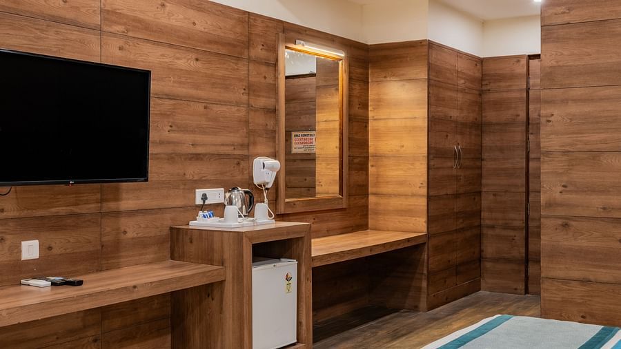 Compact King Twin Bed Room setup with mounted TV, minibar, and wood finishes at Hotel Highway King, Bilaspur.