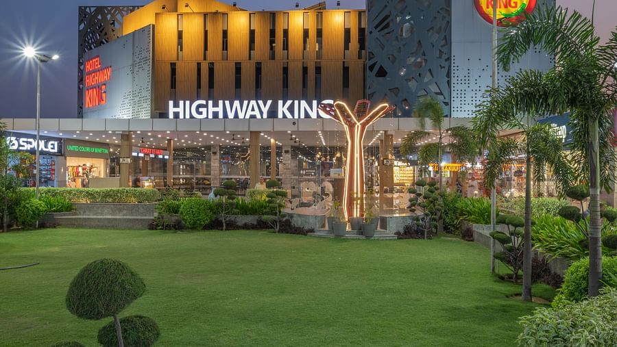 Exterior view of Hotel Highway King, Bilaspur, with illuminated facade and manicured gardens.
