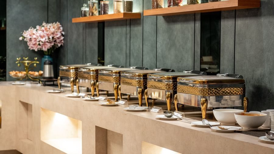 Buffet counter with a selection of dishes and jars at Hotel Royal Regency Chennai