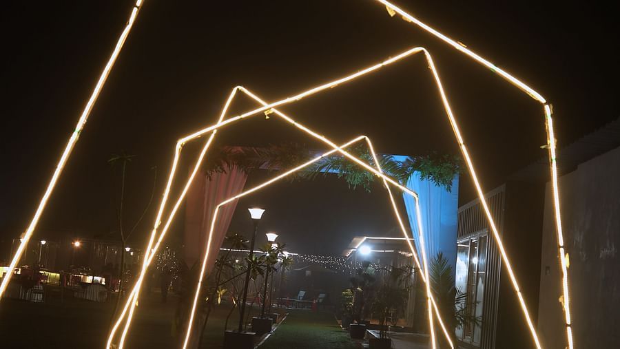 Glowing arch structures lit with warm white lights at night at Tisya Farms, Gurgaon.