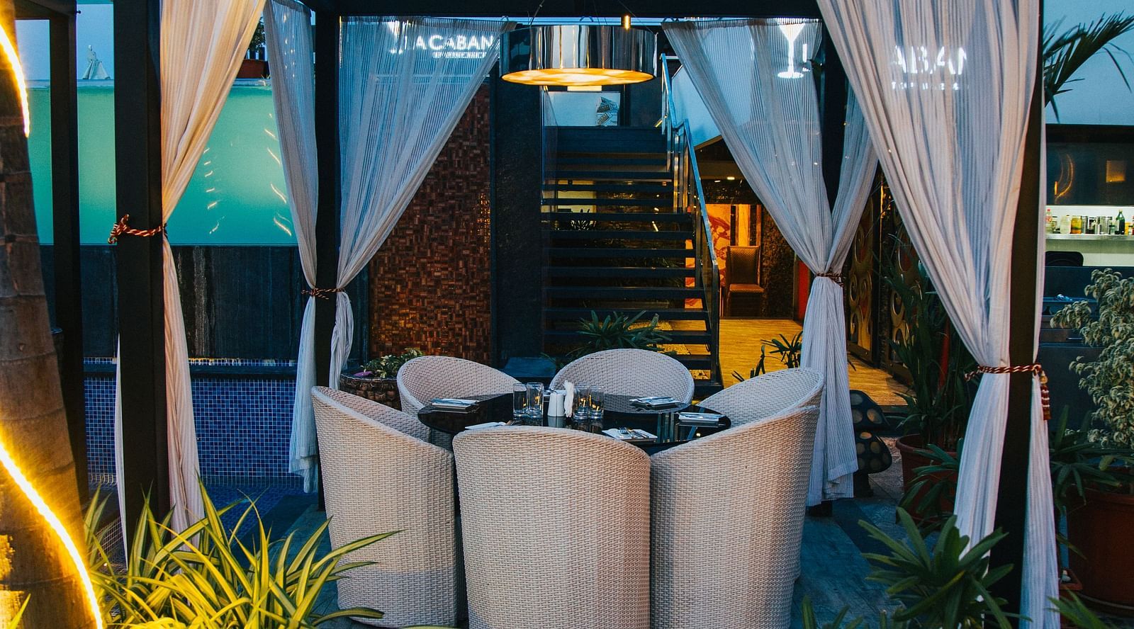 a canopy with curtains and a round table with chairs surrounding it under the canopy - Hotel Park Elanza, Chennai