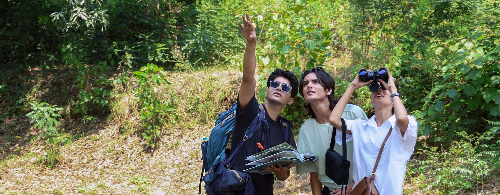 Three people pointing at the sky with a dog at The Sylvan Retreat, Dehradun.