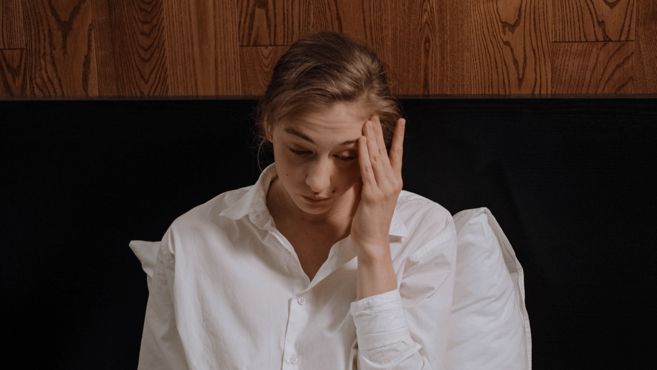 a person stressed out looking at stacks of papers and a laptop
