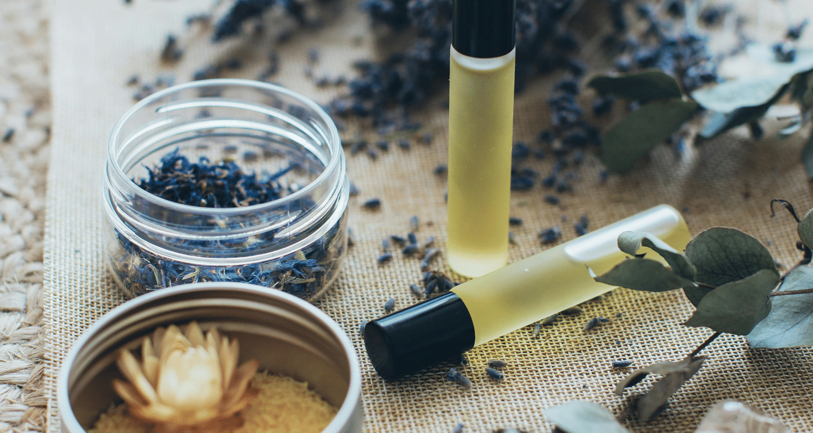 A flat surface with dried lavender, several crystals, and bottles of oil.