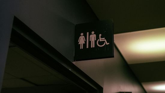 An image of an entrance of the restroom with a three signs, one of male, one for female, and one for wheelchair user 