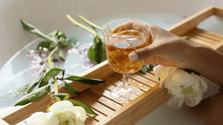 a woman holding a drink during a calming bath at the spa resorts in Goa, Azaya