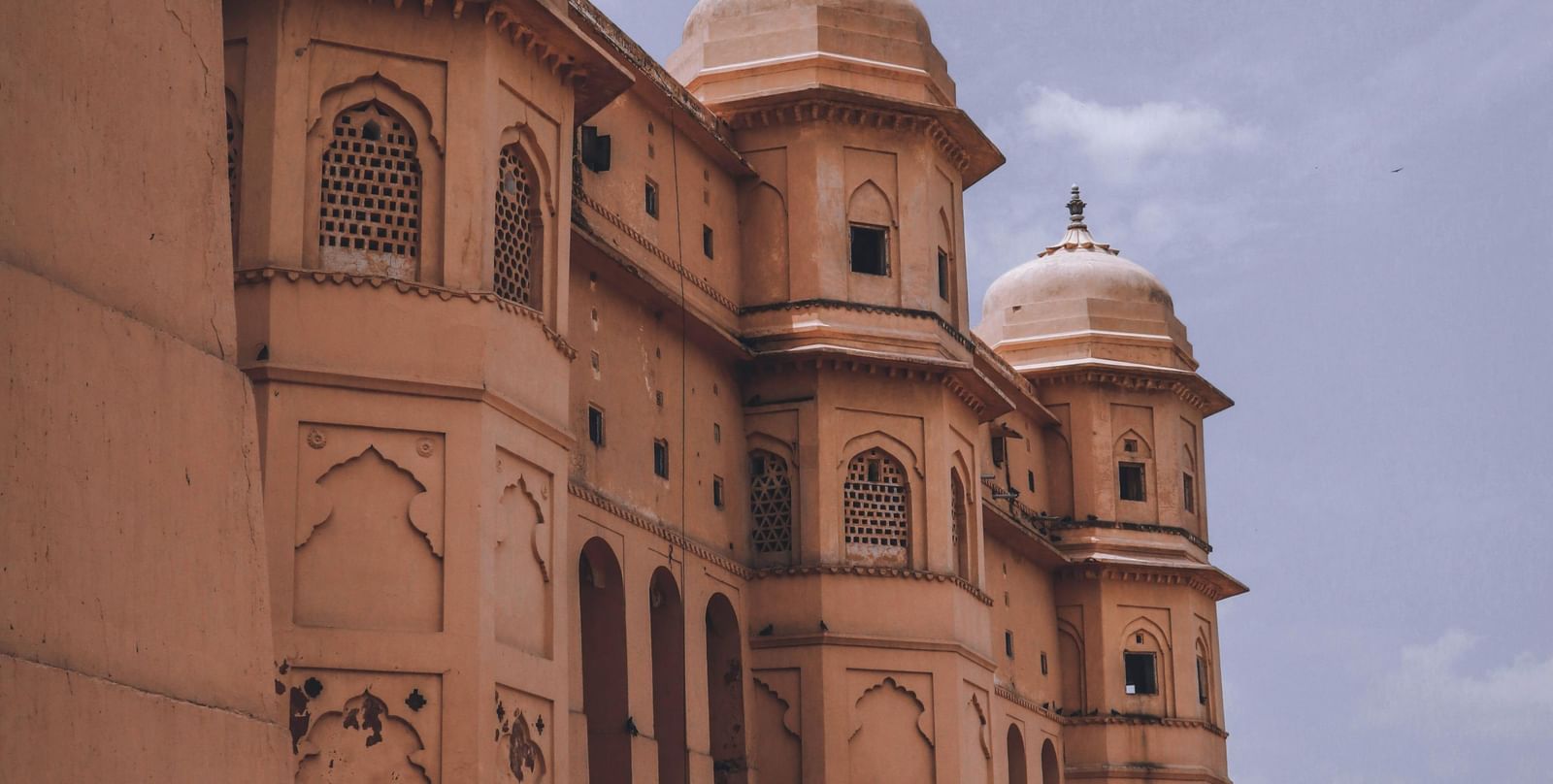Tall historic fort or palace showcasing intricate architecture against a cloudy sky.