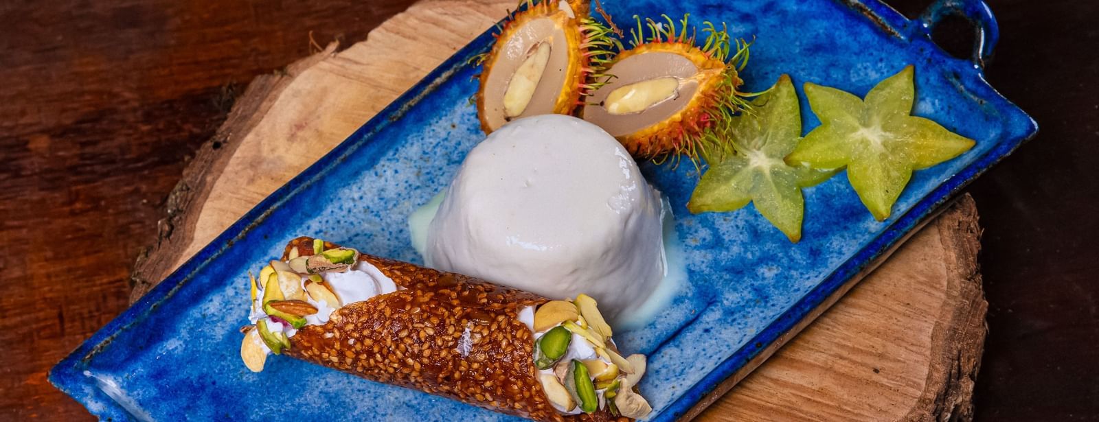 A blue plate of appetizer served on a wooden plank at The Hamuse Hotel, Kodaikanal.