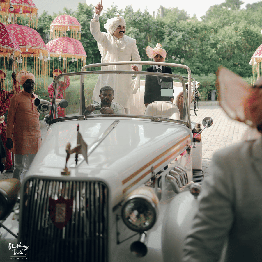 Entry of a wedding guests with groom on a vehicle and the background has some decorated umbrellas as one of the decorative elements in Marasa Sarovar Premiere, Bodhgaya.