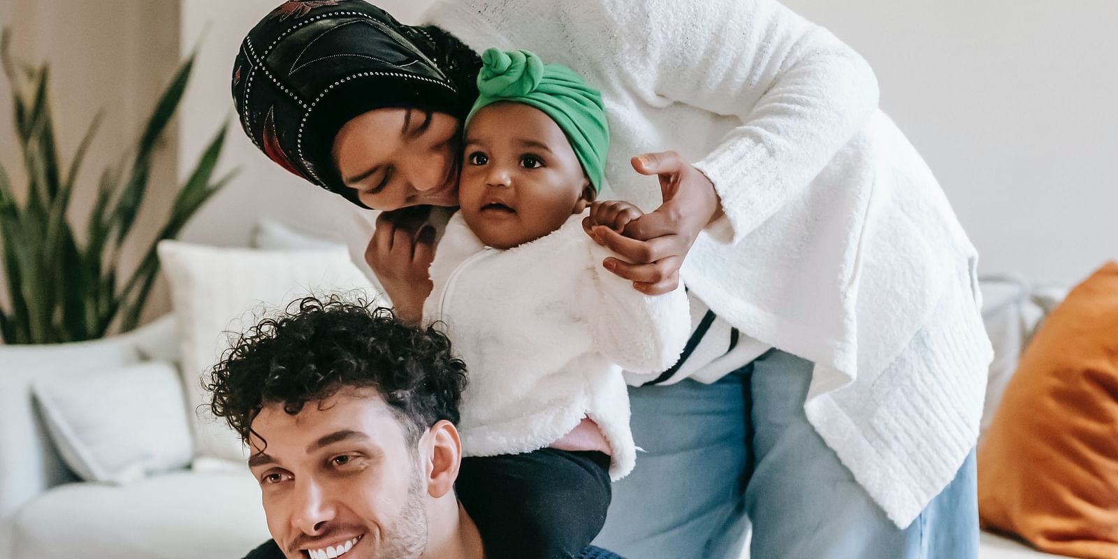 A playful moment of a young couple at home, with the woman playfully hugging the man from behind.