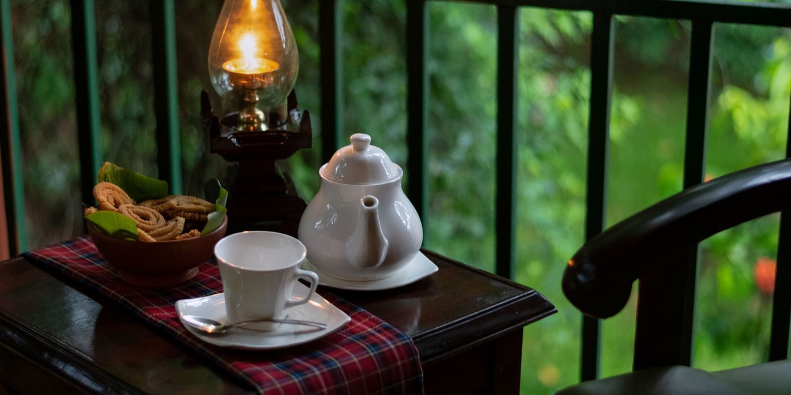an image of a tea table placed in a balcony along with two chairs - Hoysala Village Resort, Hassan