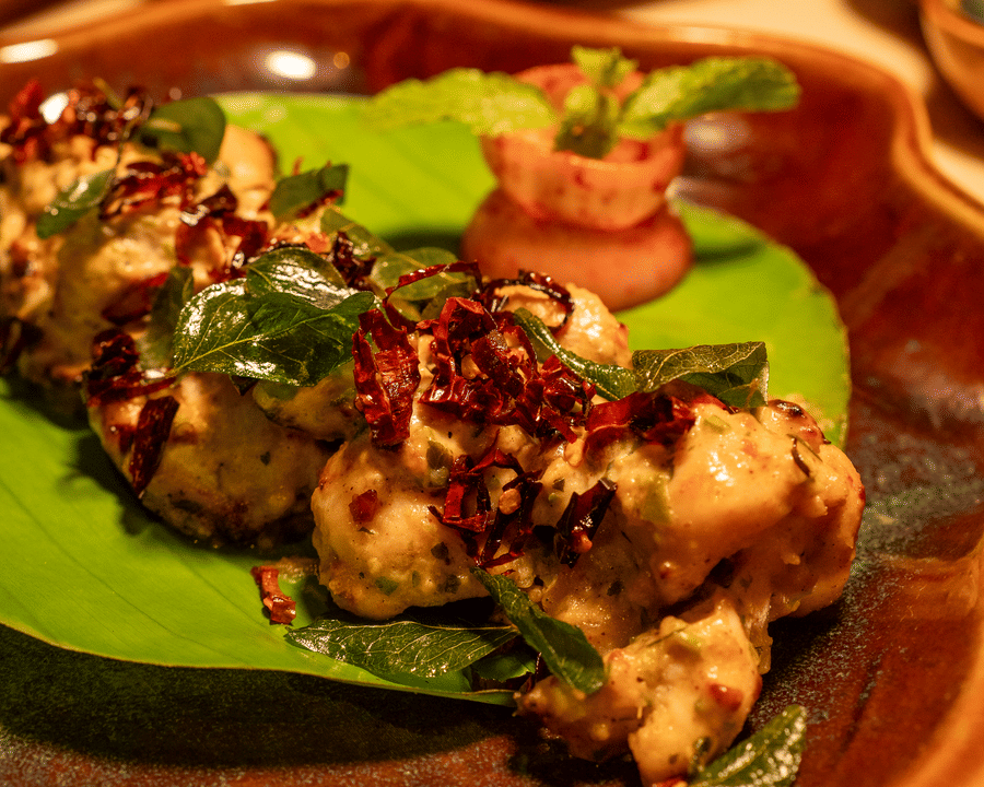 Close-up of a grilled appetiser served on a plate with garnish - Symphony Resorts