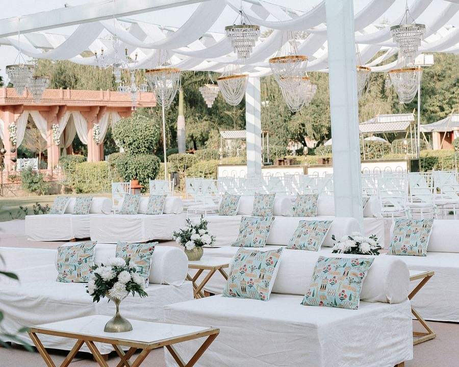 White-themed outdoor wedding reception with floral arrangements.