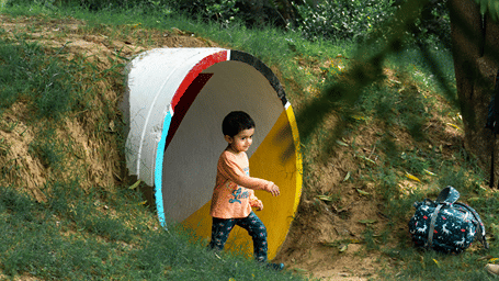 A child running out of a space with trees in the background - Karma Lakelands.