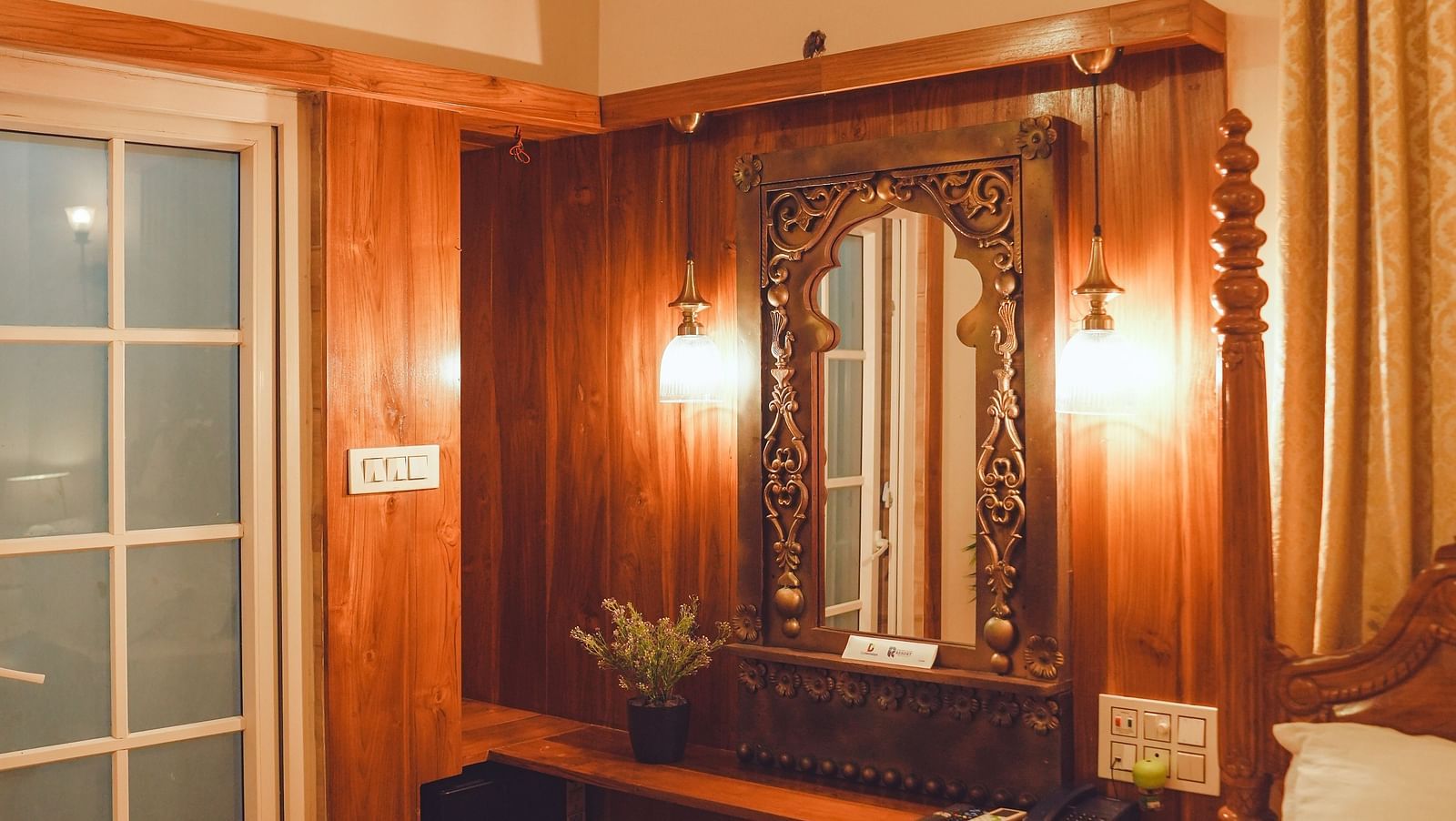 image of the dressing table with a huge mirror with two lamps wall mounted besides the mirror