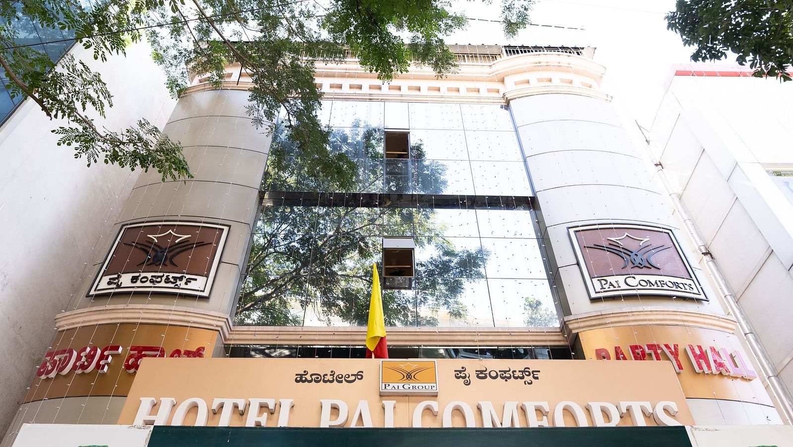 facade view of Hotel Pai Comforts, JP Nagar with a trees' branches in view