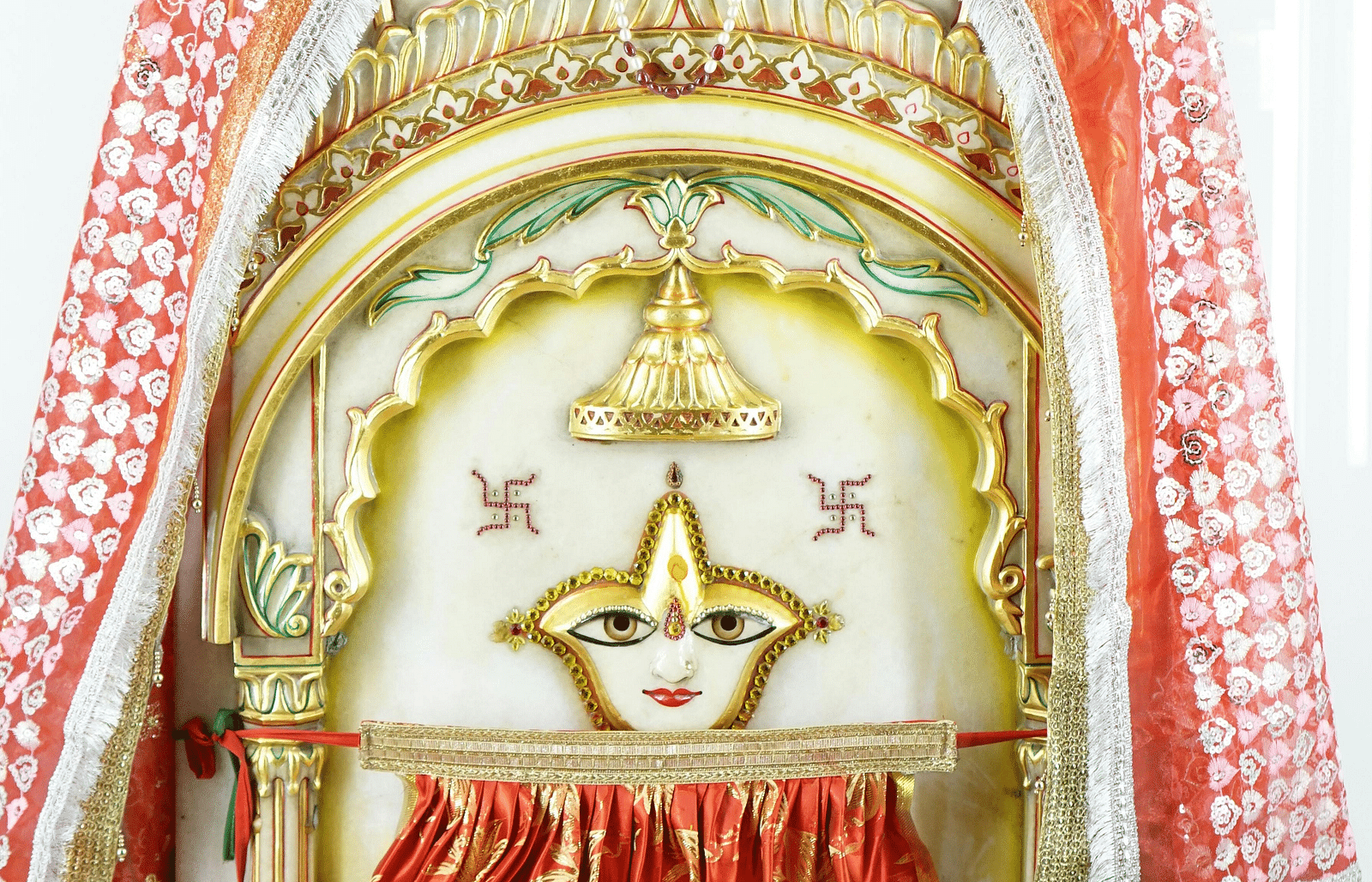 A sculpture dedicated to the Hindu goddess Sati, adorned with a silk dress and a veil draped over the top