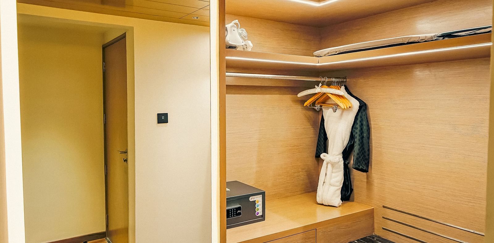 An image of a walk-in wardrobe with a bathrobe hanging from a hanger - Grand Madurai by GRT Hotels