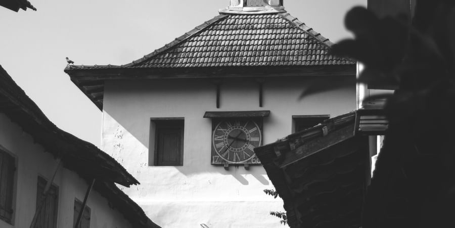 A black and white photo of a heritage building with sloped roofs, likely from a historic or culturally significant site.
