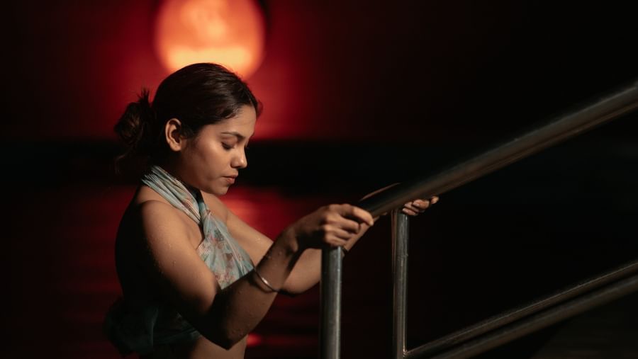 A woman in sportswear on steps in a dimly lit, dark space, featuring a red light illuminated at the background at Daksh Resort & Amusement Park, Sasan Gir.