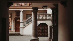 Interior of a traditional Kerala building with pillars and stairs.