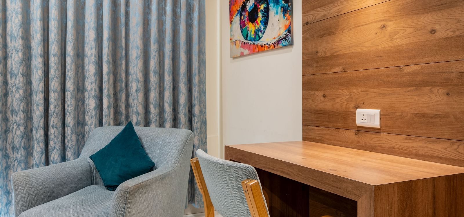 Compact corner view of room featuring a writing desk, and lounge chair at Hotel Highway King, Bilaspur.