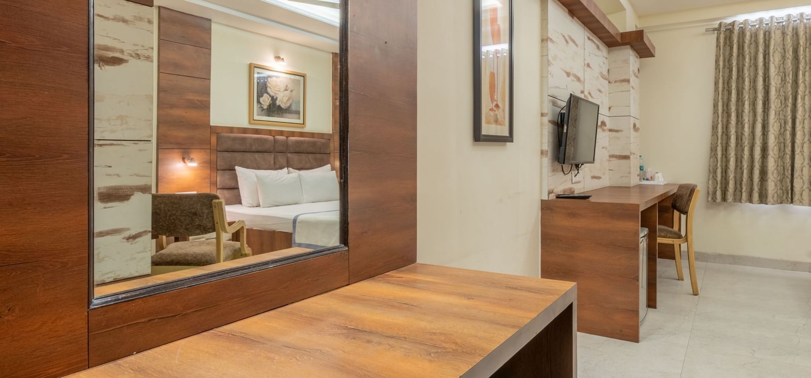 A wooden dressing table with mirror and storage drawers at Hotel Highway King, Jaipur.