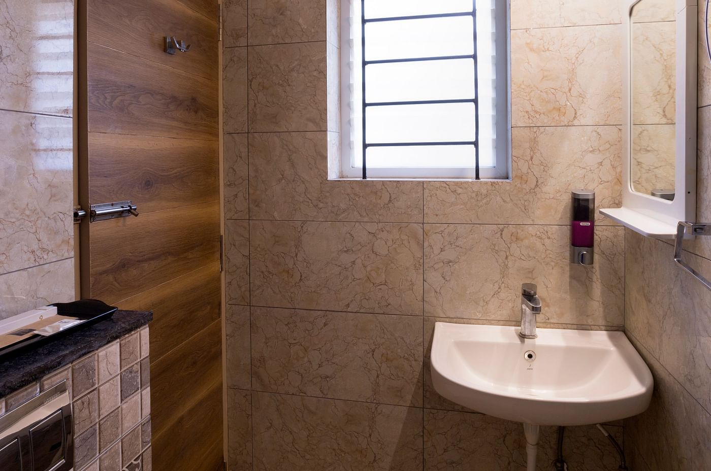 Modern bathroom with sink and wall mirror – Nirantara Resort & Spa
