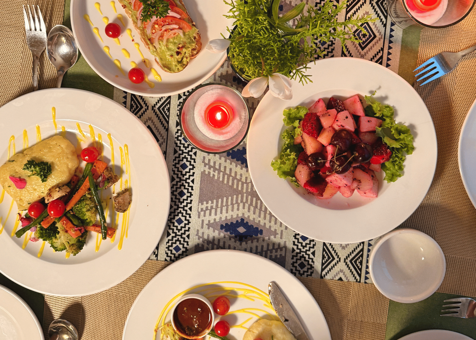 A top view of a table filled with assorted plated dishes including salads and tacos - Megha Resort & Villas, Dehradun