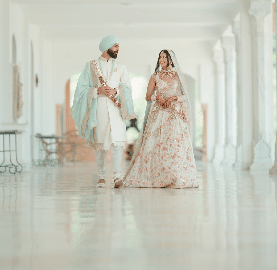 A couple posing in their wedding costumes in a corridor.