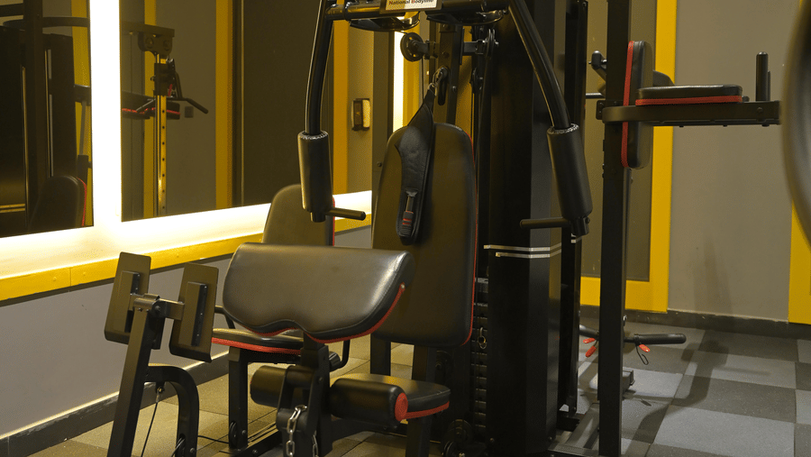 Multi-station strength machine placed in a well-lit fitness room at Hotel Sonar Bangla, Mayapur.