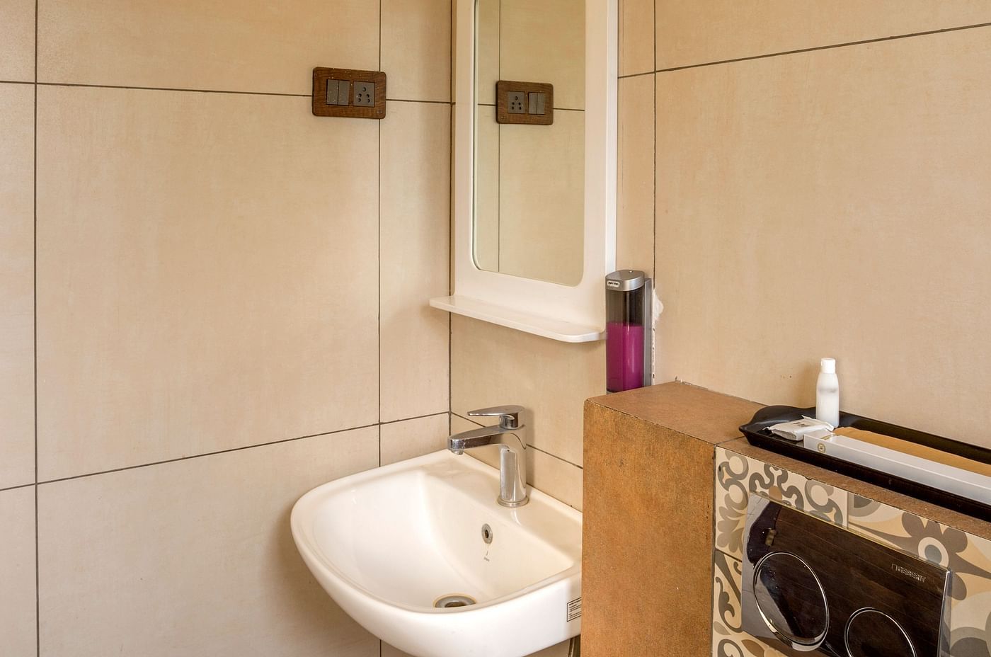 Compact bathroom with yellow accent wall and modern fixtures at Nirantara Resort
