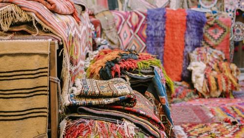 A display of colourful carpets stacked together.