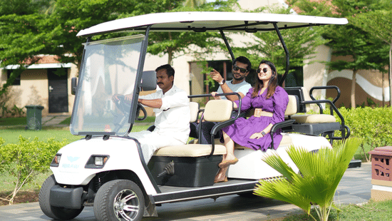 A Buggy with two people sitting behind and a person driving.