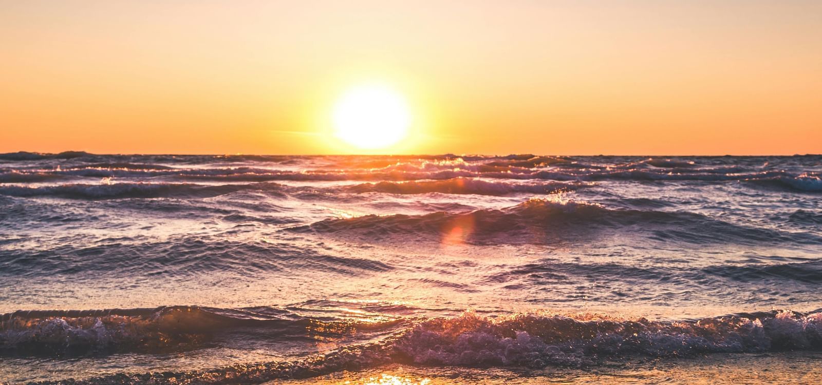 Sunset view over the sea with reflection on the water.