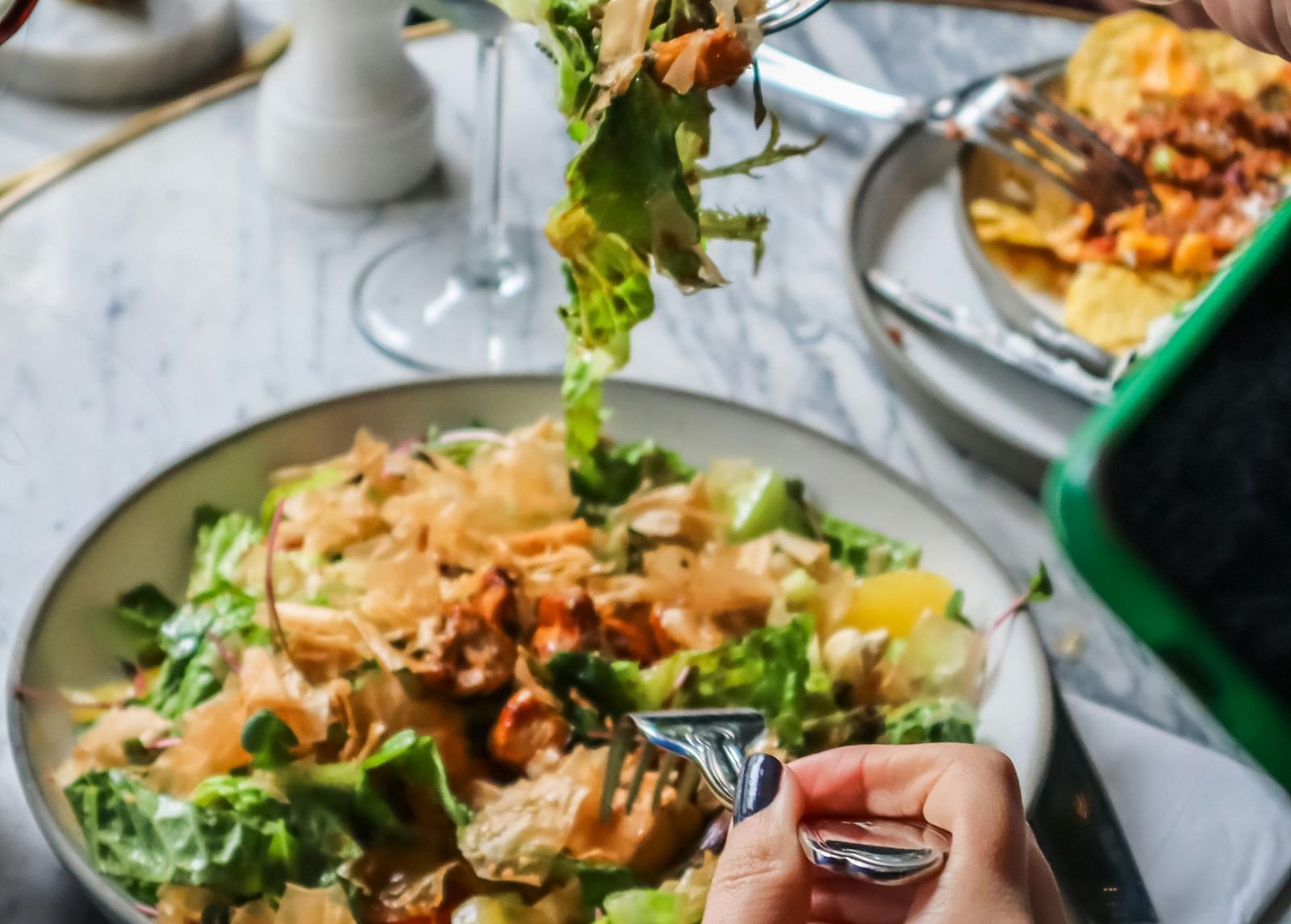 a person picking up food from the plate with a fork