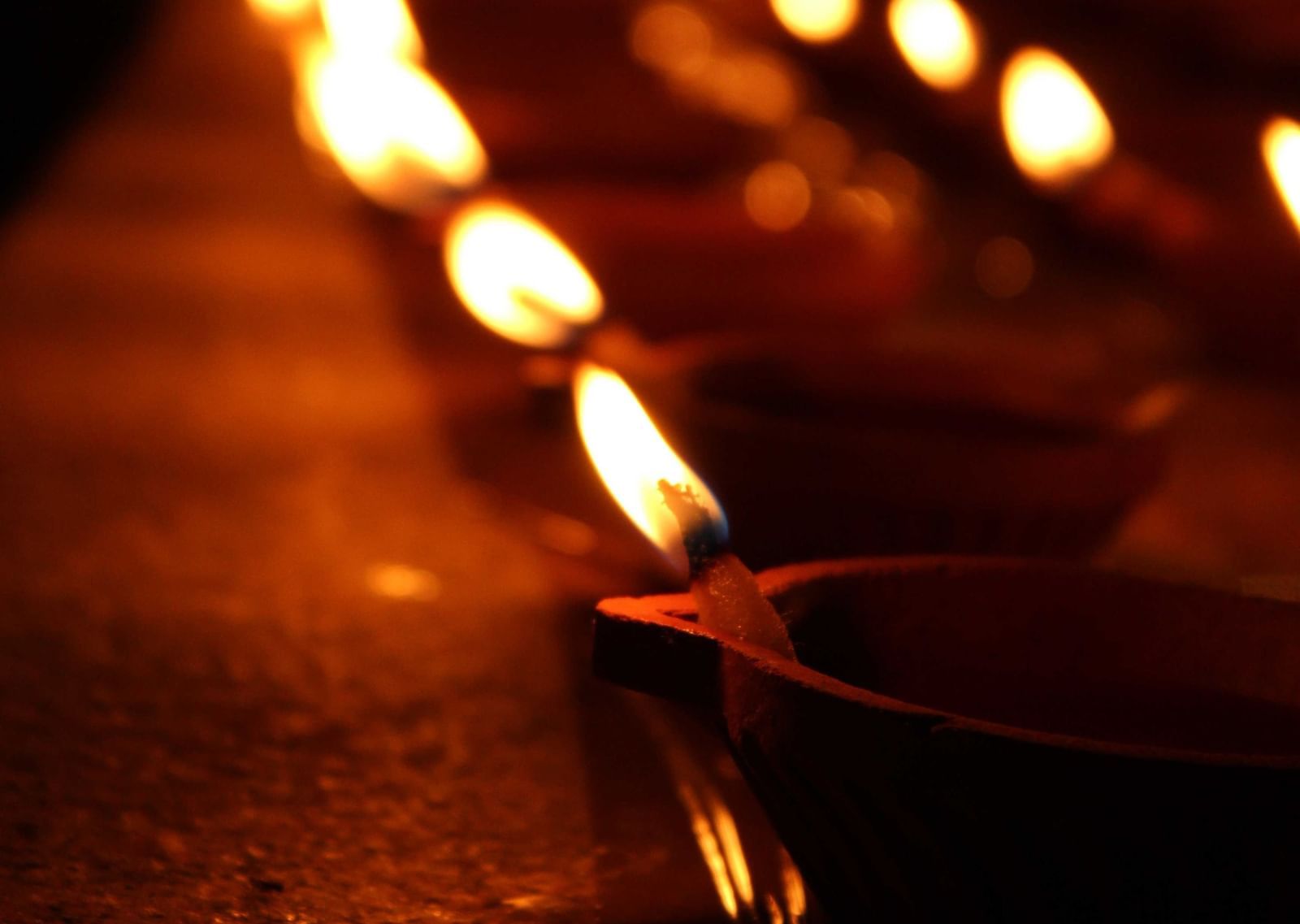 Many lit diyas places on a flat surface during Maha Deepam celebration in south india.
