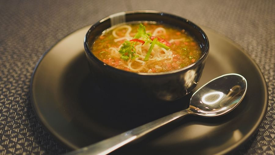 a soup in a bowl with a spoon kept on the sides