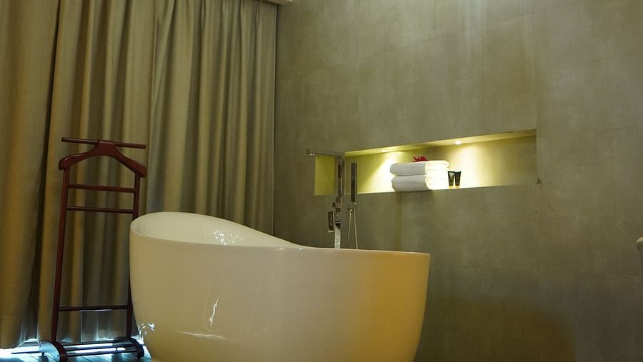 Bathtub with warm lighting and closed curtains