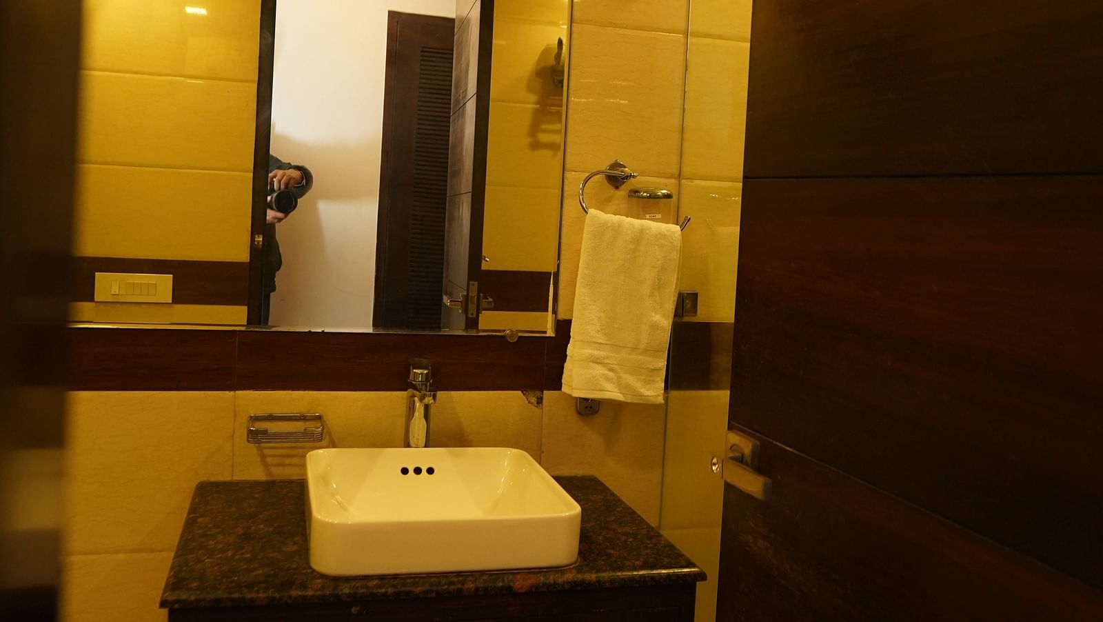 Deluxe Room featuring a bathroom area with a sink, mirror, and amenities.- Hotel Dreamland, Chandigarh