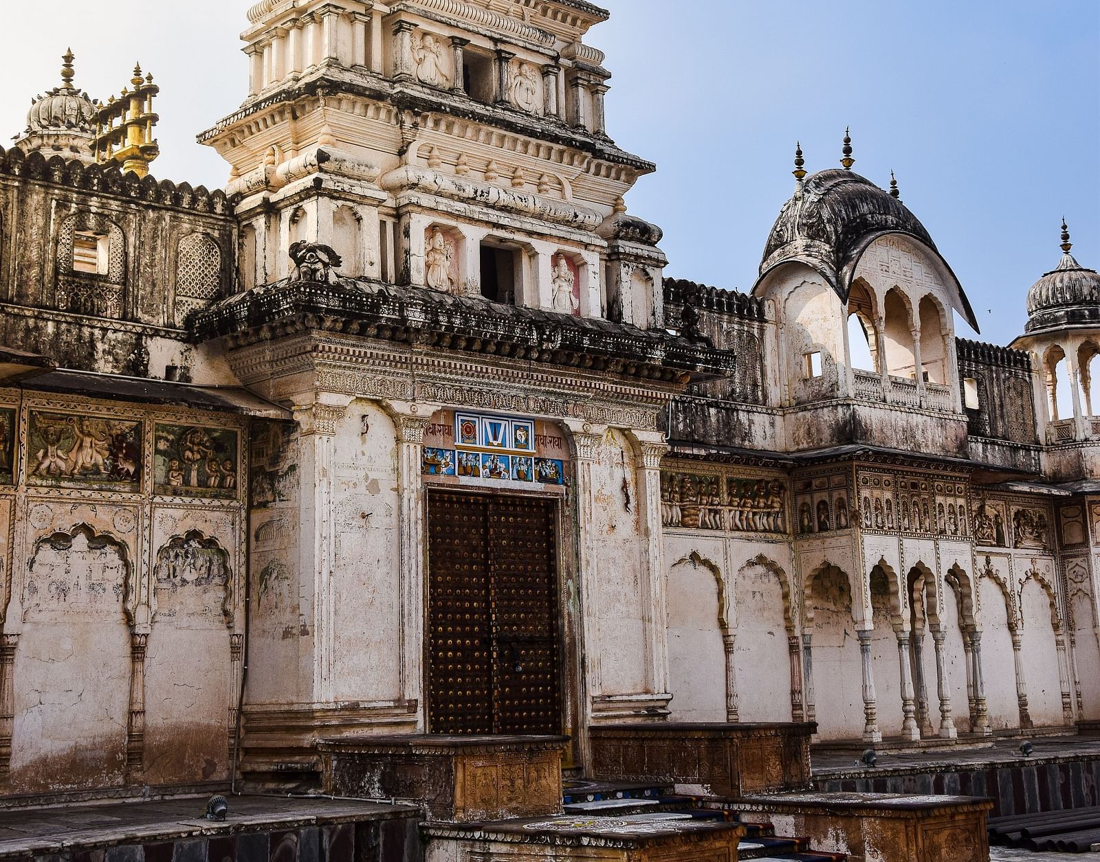 A tall, ornate temple or palace building with a white facade and intricate architectural details.