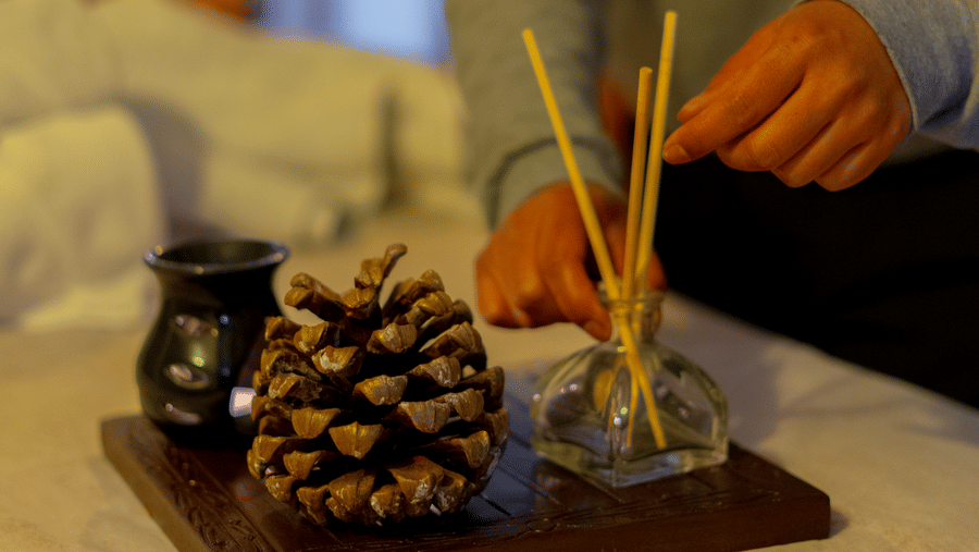 A spa therapist carefully preparing aromatic oils and incense for a wellness session - Johnson Lodge & Spa, Manali