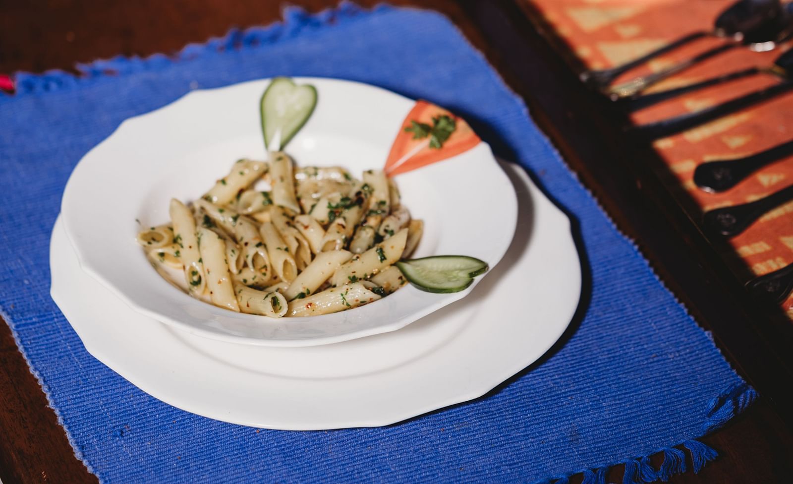 A plate of food on a placemat with cutlery, viewed from above- Shahpura Bagh.