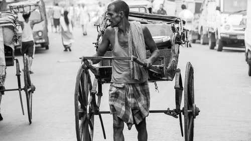 a man manoeuvring a hand-pulled rickshaw in Kolkata
