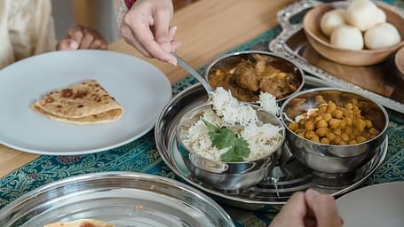 People sharing a meal with various dishes on a table, including flatbread and small bowls of food.